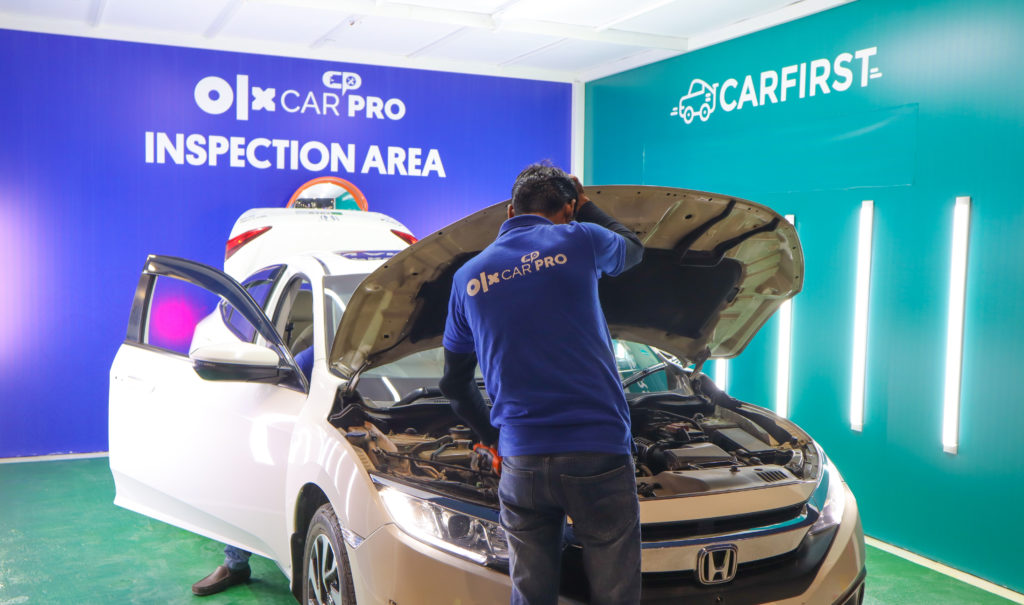 OLX CarPro Inspector carrying out a car inspection by opening the bonnet of a car at the facilitation center in Lahore. 