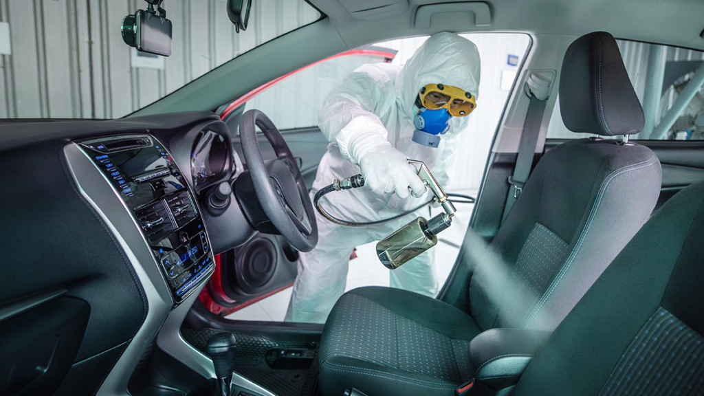 A generic image of a man disinfecting a car for a safe journey.