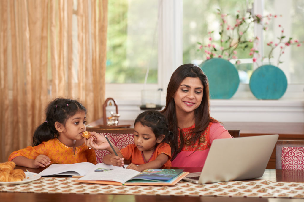 mother multitasking; working and teaching children 