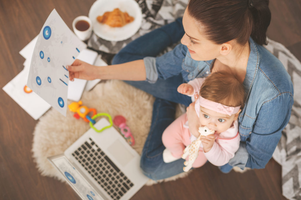 Woman multitasking; working while watching child